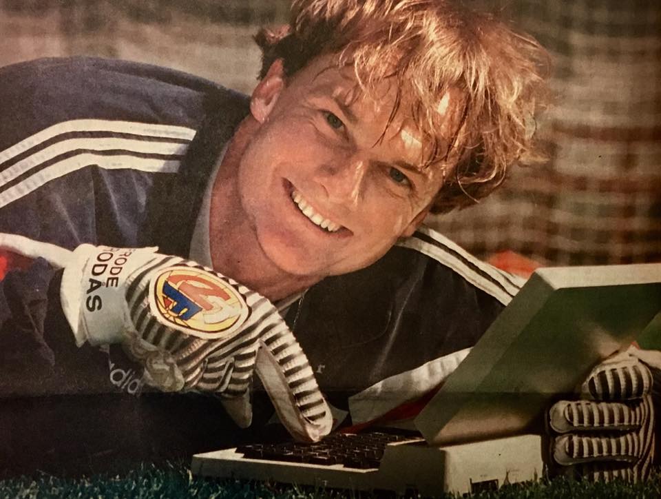 Frode Grodås viser frem noe, sannsynligvis en medalje, fra en eske. Han peker ned på det med keeperhansker. 