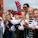 Barn i bunad som vifter og jubler med flagg i sak om drikking 17. mai