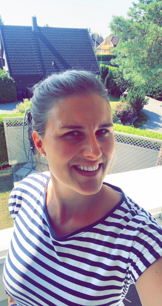Selfie av Ida Braarud som smiler til kamera, hun har på seg en teskjorte med striper.