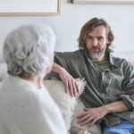Mann i 40 årene i samtale med eldre dame.