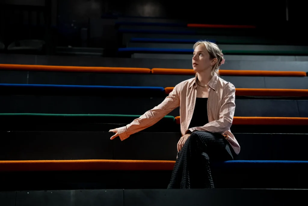 Portrett av Anna Ladegaard som sitter i teatersalen på Det Andre Teatret.